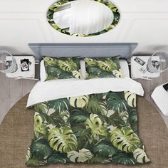 a bed with green leaves on it next to a round mirror