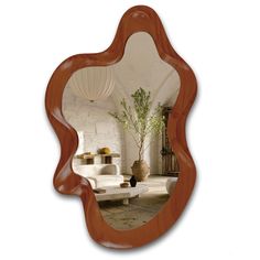 a mirror that is on the wall in front of a couch and table with a potted plant