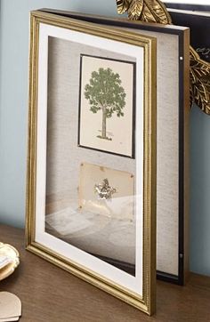 a framed photo with a tree in it on a table next to a pair of scissors