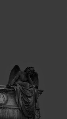 an angel statue sitting on top of a building