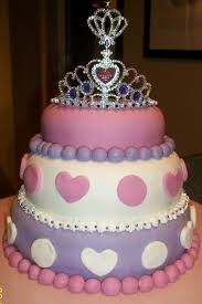 a three tiered cake decorated with pink, purple and white polka dots and a tiara on top