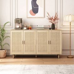 a living room with a sideboard and potted plant on the floor next to it