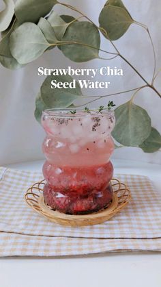 strawberry chia seed water in a glass jar on a plate next to a plant