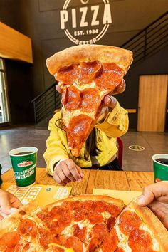 a girl eating a slice of pepperoni pizza