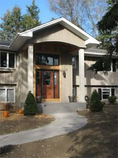 the front entrance to a house with trees in the background