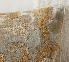 a close up of a decorative pillow on a bed