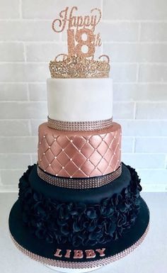 a three tiered cake decorated with gold and black ruffles