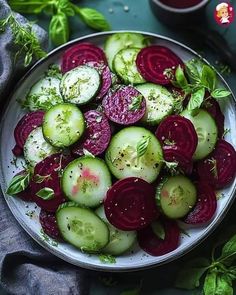 a white plate topped with sliced up beets and cucumbers