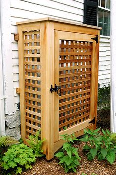 a wooden cabinet sitting outside next to a white house with the words diy rain catcher on it