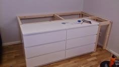 a white dresser sitting on top of a hard wood floor