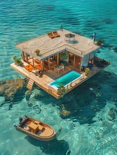 an aerial view of a house on stilts in the ocean with a boat nearby