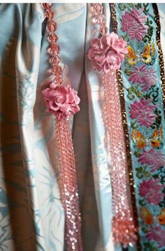 pink flowers are attached to the side of a blue dress with sequins on it