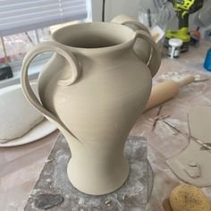 a white vase sitting on top of a table