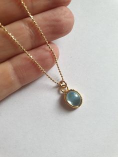 This minimalist Blue Topaz solid gold necklace was designed with a light blue December birthstone pendant, to beautifully accompany you through your busy days. The classic simple design is always pretty for day and evening, work or fun. The gold Blue Topaz necklace is handmade and delicate and available both with a 9kt or 14 karat pendant. The gold chain is made of 14k and available in a couple lengths. The clear Blue topaz necklace is a great birthstone necklace and a perfect chic and elegant g Minimalist Gold Birthstone Necklace With Gemstone, Minimalist Birthstone Oval Pendant Necklace, Minimalist Oval Pendant Birthstone Necklace, Minimalist Birthstone Necklace With Oval Pendant, Blue Dainty Birthstone Necklace For Anniversary, Blue Topaz Oval Pendant Necklace With Birthstone, Blue Topaz Birthstone Necklace With Oval Pendant, Minimalist Gold Jewelry With Blue Topaz, Blue Round Pendant Necklace For May Birthstone