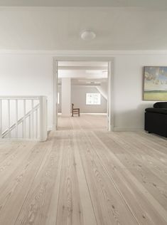 an empty living room with white walls and wood flooring on the bottom half of the room