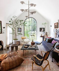 a living room filled with furniture and a fire place next to a large arched window