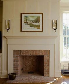 a living room with a fire place and a painting hanging on the wall above it