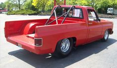 an old red pick up truck parked in a parking lot