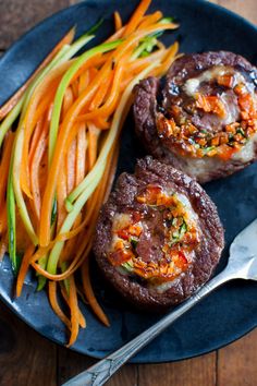 some food on a blue plate with carrots and meat