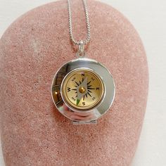 "Introducing the timeless and classic silver compass locket - a stunning addition to your jewelry collection. Crafted from smooth and shiny silver plated brass, this locket measures 27mm in diameter and has a working compass set into the front. The brass compass features a delicate glass face and adds an extra touch of elegance to this already beautiful piece.  This piece is lightweight and has a delicate chain. The locket opens to reveal a secret place to keep pictures, messages, or any small t Cheap Metal Pendant Locket Necklace, Silver Pocket Watch With Locket As Gift, Compass Locket, Nickel-free Silver Pocket Watch As Gift, Silver Nickel-free Pocket Watch As Gift, Silver Pocket Watch With Locket Pendant, Silver Round Pocket Watch With Locket, Compass Design Medallion Locket Necklace As Gift, Medallion Locket Necklace With Compass Design For Gift