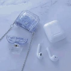 an assortment of ear buds and accessories on a white surface with a chain attached to it