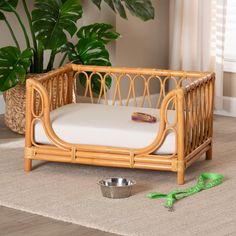 a dog bed with a bowl and green scissors on the floor next to it,