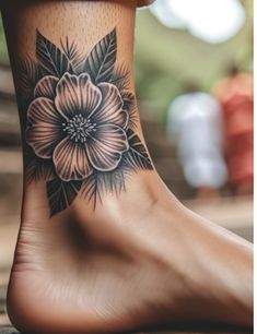 a woman's foot with a flower tattoo on it