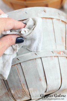 a person is cleaning an old basket with a rag and cloth on the bottom half of it