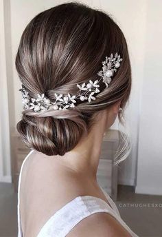 a woman wearing a bridal hair comb with flowers and leaves on it's head