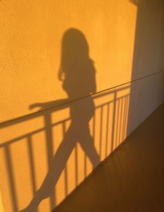 the shadow of a person walking on a balcony