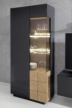 a black cabinet with glass doors and shelves filled with glasses on it's sides