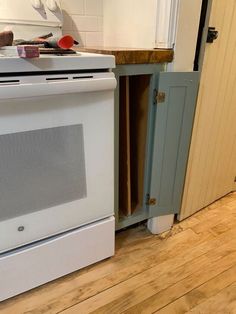 a white stove top oven sitting inside of a kitchen next to a wooden countertop