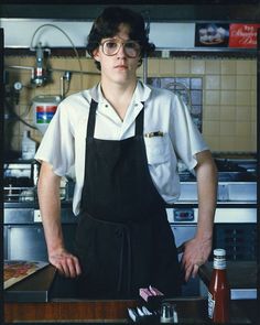 a man in an apron standing at a counter