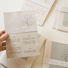 several pieces of paper with drawings on them being held up by someone's hand