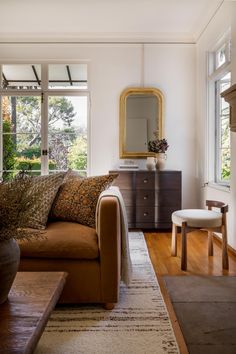 a living room filled with furniture and a large mirror on the wall over a fireplace