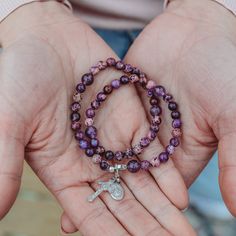 This beautiful gemstone rosary bracelet features Amethyst beads as the paters and purple aquaterra beads as the aves. Each of our stretch and wrap rosary bracelets is a full rosary. Each bracelet also includes a “bookmark” crucifix medal. This medal is moveable and can help you keep track of where you are at in your rosary as you pray throughout your day. Each bracelet is strung on durable elastic making it easy to stretch and wrap around your wrist without fear of snapping it. The medal accent Adjustable Purple Rosary Bracelet, Adjustable Purple Spiritual Rosary Bracelet, Adjustable Purple Rosary Bracelet With 8mm Beads, Custom Jewelry Necklaces, Pearl Rosary, Rosary Bracelet, Gifts Under 10, Amethyst Beads, Keep Track