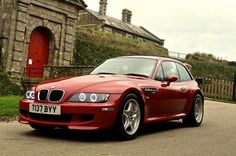 a red sports car parked in front of a building