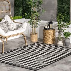 a black and white checkered rug on the floor next to a wicker chair