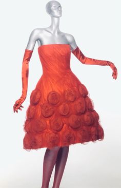 a mannequin dressed in an orange dress with roses on it's skirt