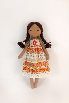 a doll with brown hair wearing a dress