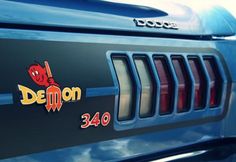 the rear end of a blue car with demon stickers on it