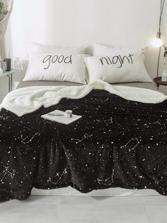 a bed with two pillows that say good night and stars on the comforter next to it