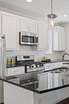 a kitchen with white cabinets and stainless steel appliances