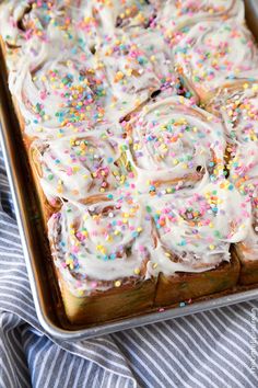 a cake with white frosting and sprinkles on it sitting in a pan