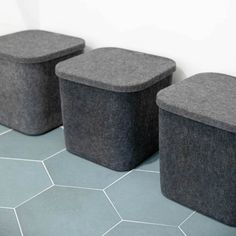 three black and gray storage containers sitting next to each other on a blue tiled floor