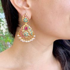 Featuring a pair of gold plated silver earrings embellished with pearls, turquoises and ruby lookalike stones. The earrings weigh a comfortable to wear 15 gms and come with a bombay screw closure. Temple Jewelry Pearl Drop Earrings, Festive Turquoise Temple Jewelry Earrings, Wedding Ruby Meenakari Earrings, Gold Bollywood Danglers With Ruby, Elegant Turquoise Kundan Earrings, Ceremonial Ruby Earrings With Meenakari Detailing, Festival Ruby Chandelier Earrings In Gold, Turquoise Meenakari Temple Jewelry Earrings, Elegant Turquoise Meenakari Earrings