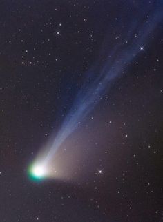 an object in the sky with stars and a green light shining from it's side