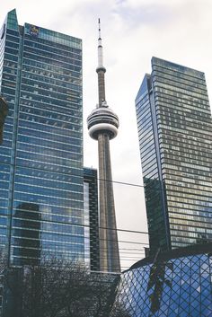 there are many tall buildings next to each other in the city, including one that has a television tower on top