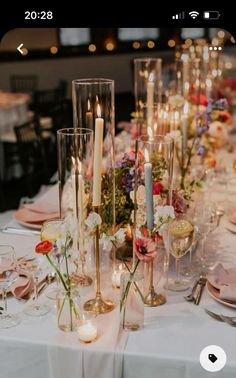 the table is set with candles, flowers and wine glasses for an elegant wedding reception