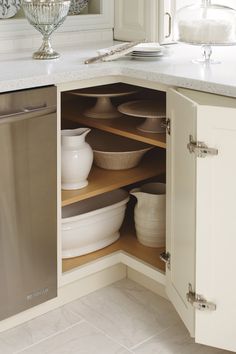 an open cabinet in a kitchen filled with dishes